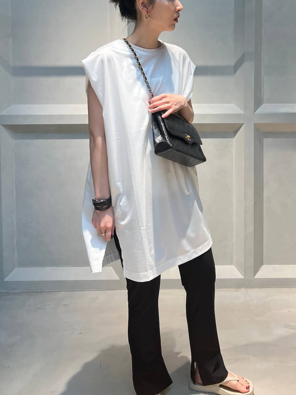 ブラック系のその他パンツ、ホワイト系のTシャツ/カットソー、ベージュ系のサンダルを着用したレディースの夏コーディネートの5枚目の写真