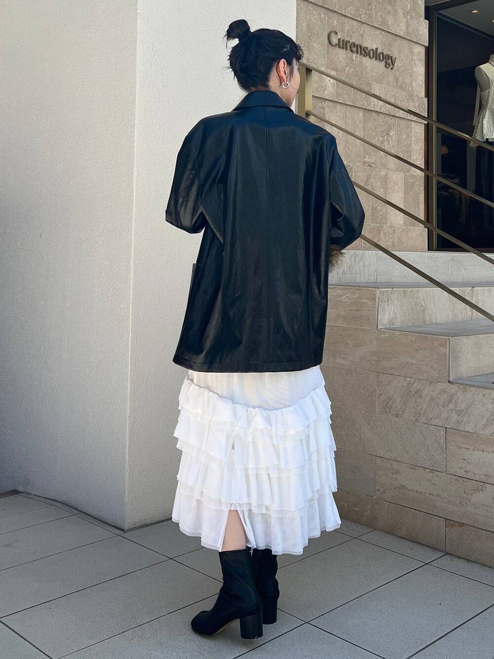 ホワイト系のタンクトップ、ホワイト系のスカート、ブラック系のブルゾンを着用したレディースの夏コーディネートの2枚目の写真