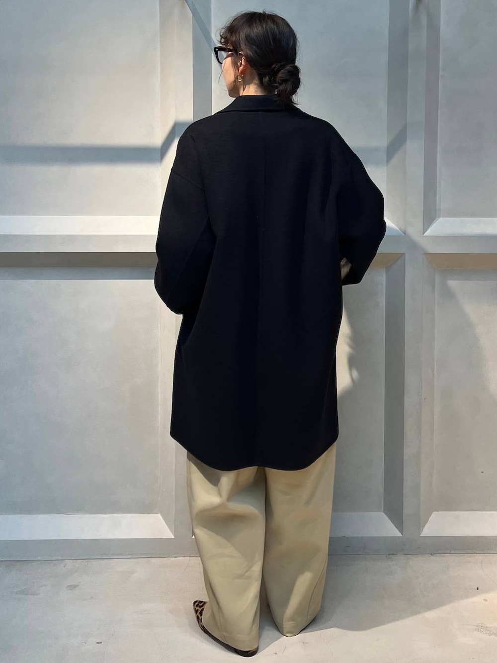 ホワイト系のTシャツ/カットソー、ブラウン系のその他パンツ、ブルー系のチェスターコートを着用したレディースの秋コーディネートの3枚目の写真