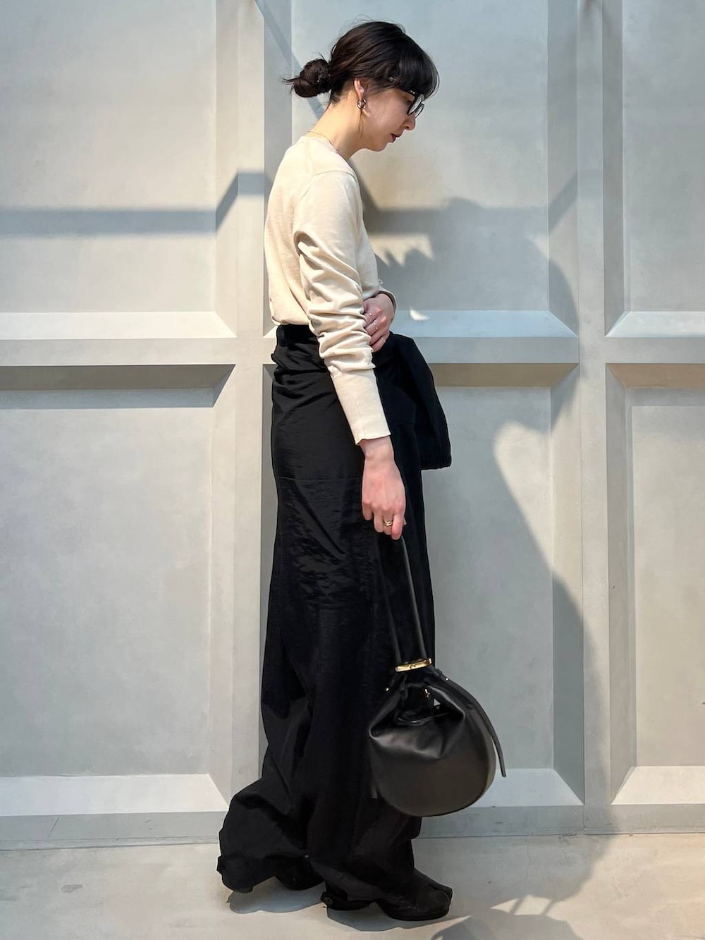 ホワイト系のニット/セーター、ブラック系のつなぎ/オールインワン、シルバー系のネックレスを着用したレディースの春コーディネートの4枚目の写真