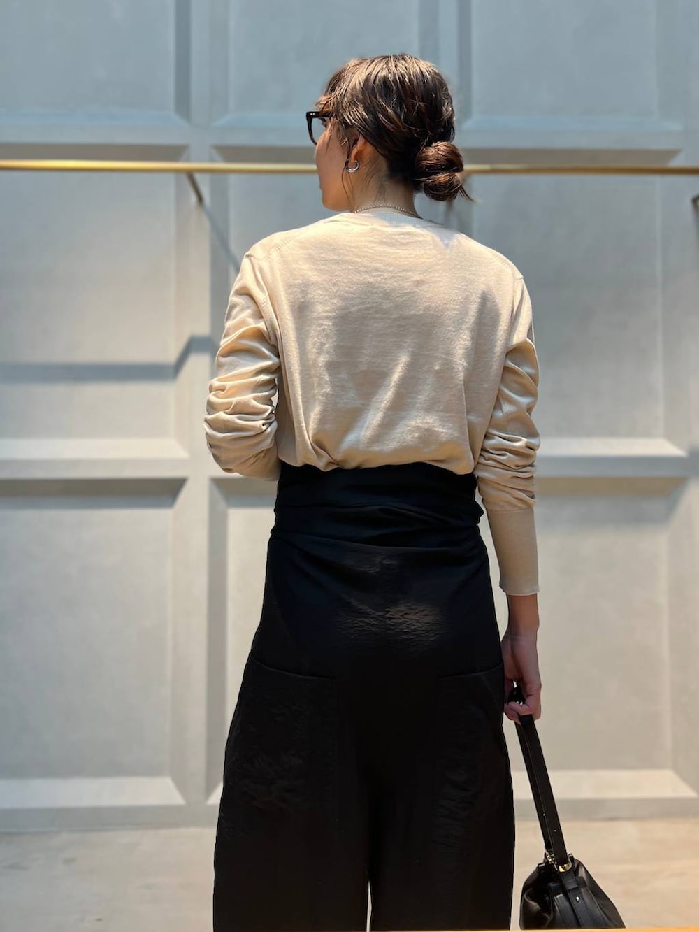 ホワイト系のニット/セーター、ブラック系のつなぎ/オールインワン、シルバー系のネックレスを着用したレディースの春コーディネートの7枚目の写真