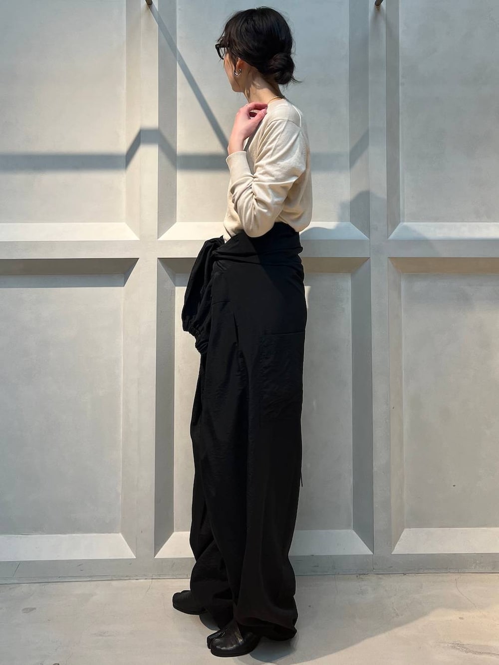 ホワイト系のニット/セーター、ブラック系のつなぎ/オールインワン、シルバー系のネックレスを着用したレディースの春コーディネートの2枚目の写真