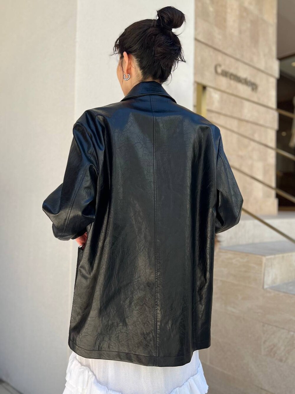 ホワイト系のタンクトップ、ホワイト系のスカート、ブラック系のブルゾンを着用したレディースの夏コーディネートの6枚目の写真