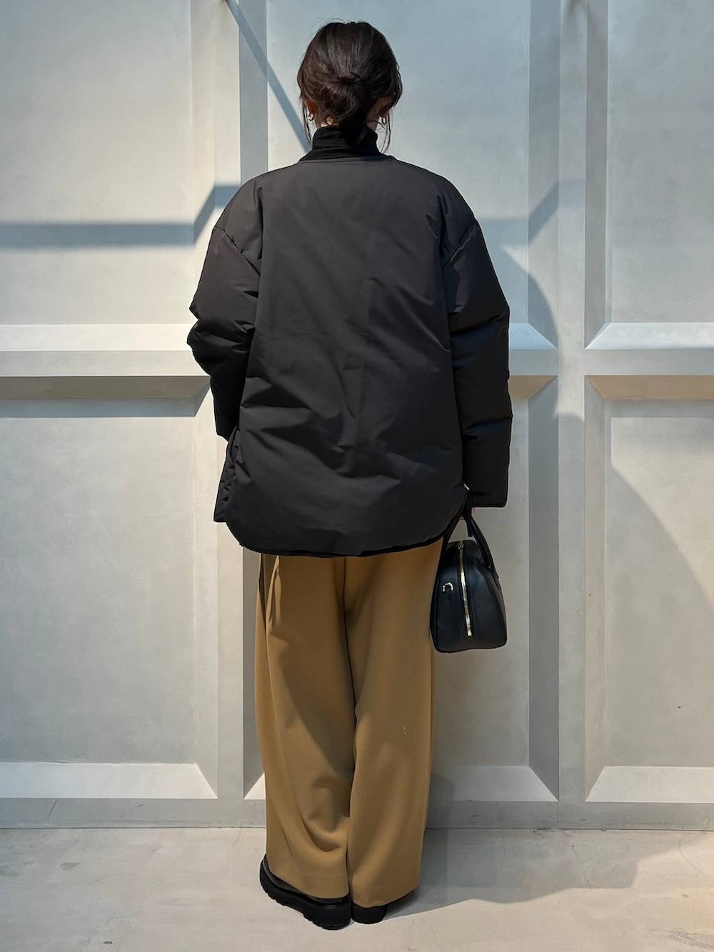 ブラック系のダウンジャケット/コート、ブラック系のニット/セーターを着用したレディースの冬コーディネートの3枚目の写真