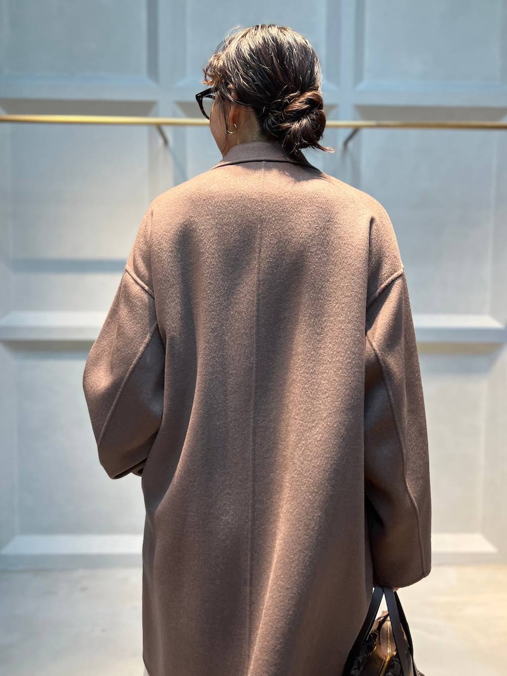 ホワイト系のその他パンツ、ベージュ系のニット/セーター、ブラウン系のチェスターコートを着用したレディースの秋コーディネートの5枚目の写真