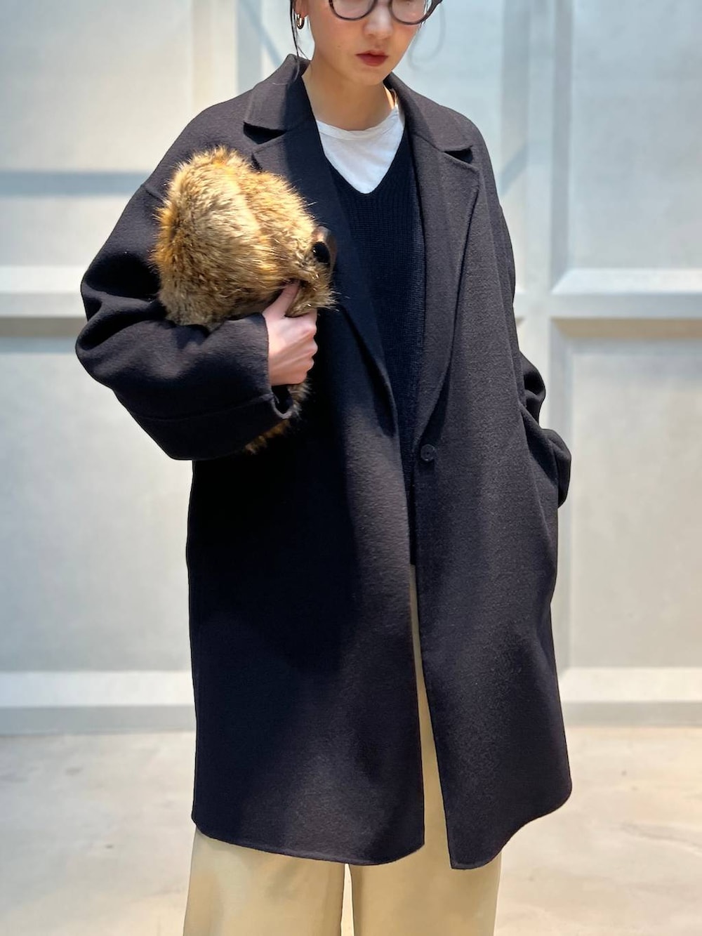 ホワイト系のTシャツ/カットソー、ブラウン系のその他パンツ、ブルー系のチェスターコートを着用したレディースの秋コーディネートの5枚目の写真