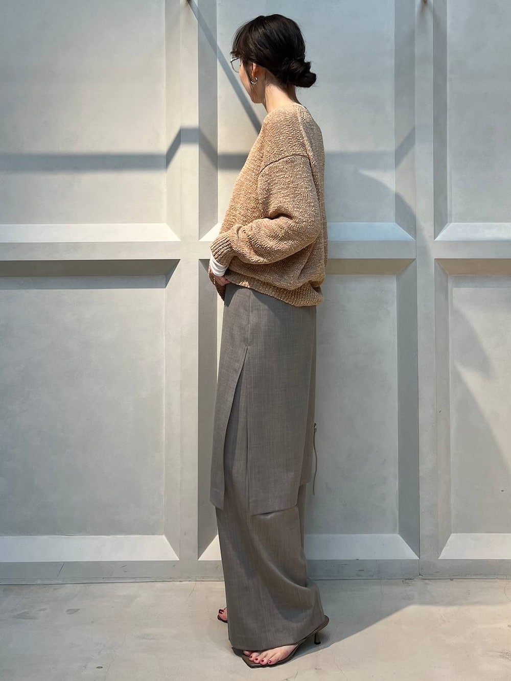 ホワイト系のTシャツ/カットソー、グレー系のその他パンツ、ベージュ系のニット/セーターを着用したレディースの春コーディネートの2枚目の写真