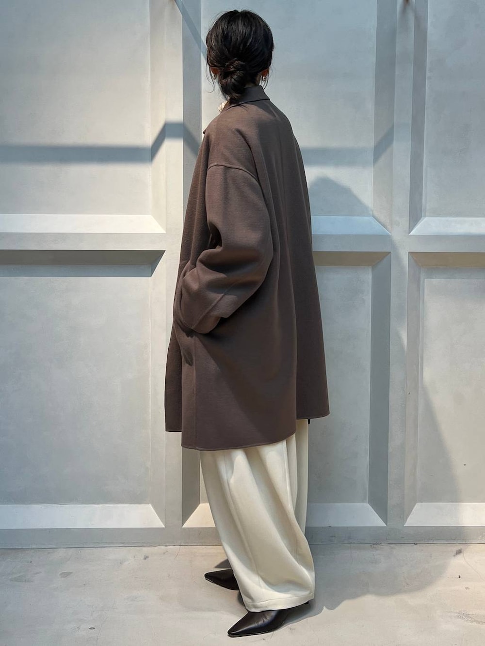 ホワイト系のその他パンツ、ベージュ系のニット/セーター、ブラウン系のチェスターコートを着用したレディースの秋コーディネートの2枚目の写真