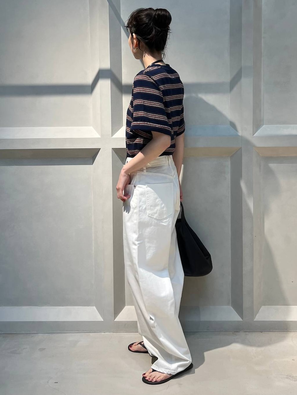 ホワイト系のデニムパンツ、ブルー系のTシャツ/カットソー、ブラック系のショルダーバッグを着用したレディースの夏コーディネートの2枚目の写真