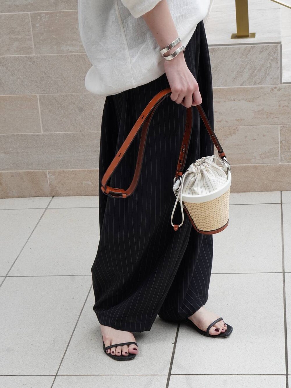 ホワイト系のシャツ/ブラウス、ブラック系のその他パンツ、グレー系のバングル/リストバンドを着用したレディースの夏コーディネートの7枚目の写真