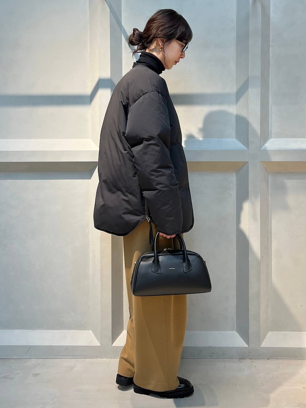 ブラック系のダウンジャケット/コート、ブラック系のニット/セーターを着用したレディースの冬コーディネートの4枚目の写真