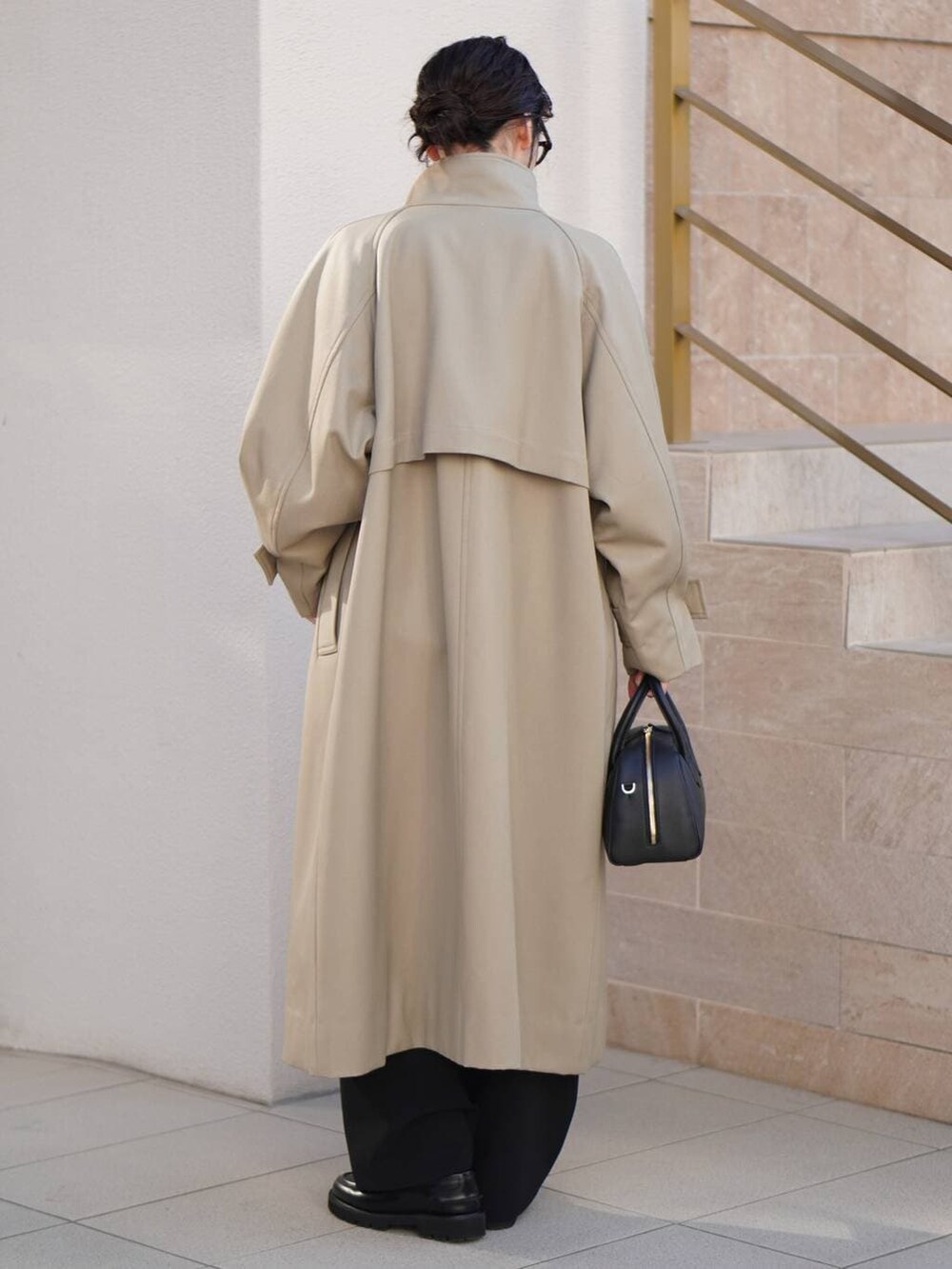 ブラック系のその他パンツ、ベージュ系のトレンチコート、ホワイト系のニット/セーターを着用したレディースの秋コーディネートの3枚目の写真