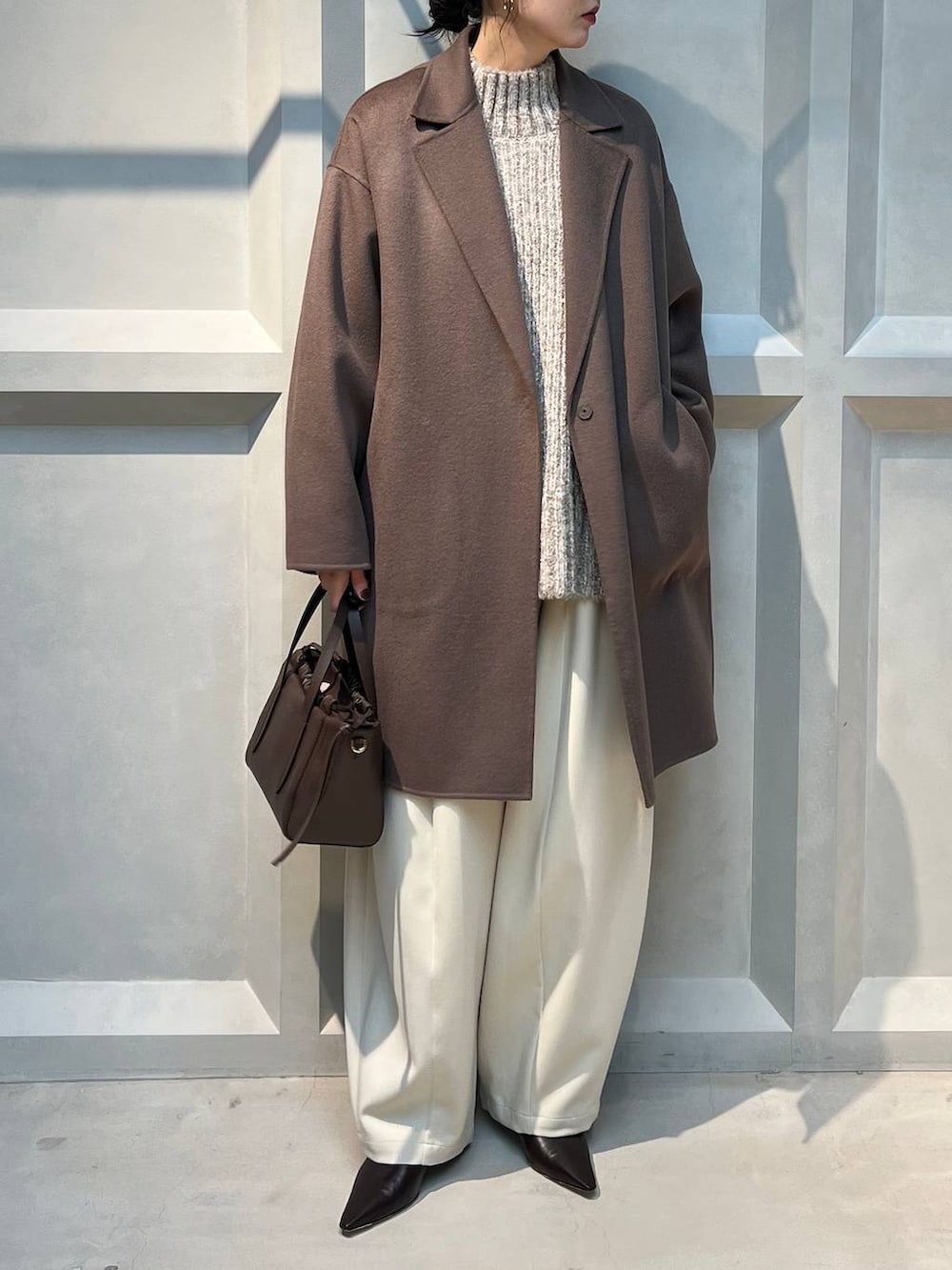 ホワイト系のその他パンツ、ベージュ系のニット/セーター、ブラウン系のチェスターコートを着用したレディースの秋コーディネートの3枚目の写真