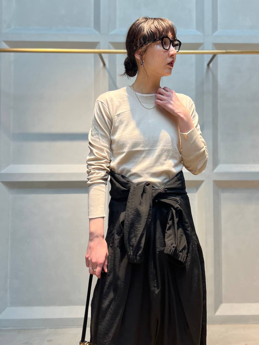 ホワイト系のニット/セーター、ブラック系のつなぎ/オールインワン、シルバー系のネックレスを着用したレディースの春コーディネートの5枚目の写真