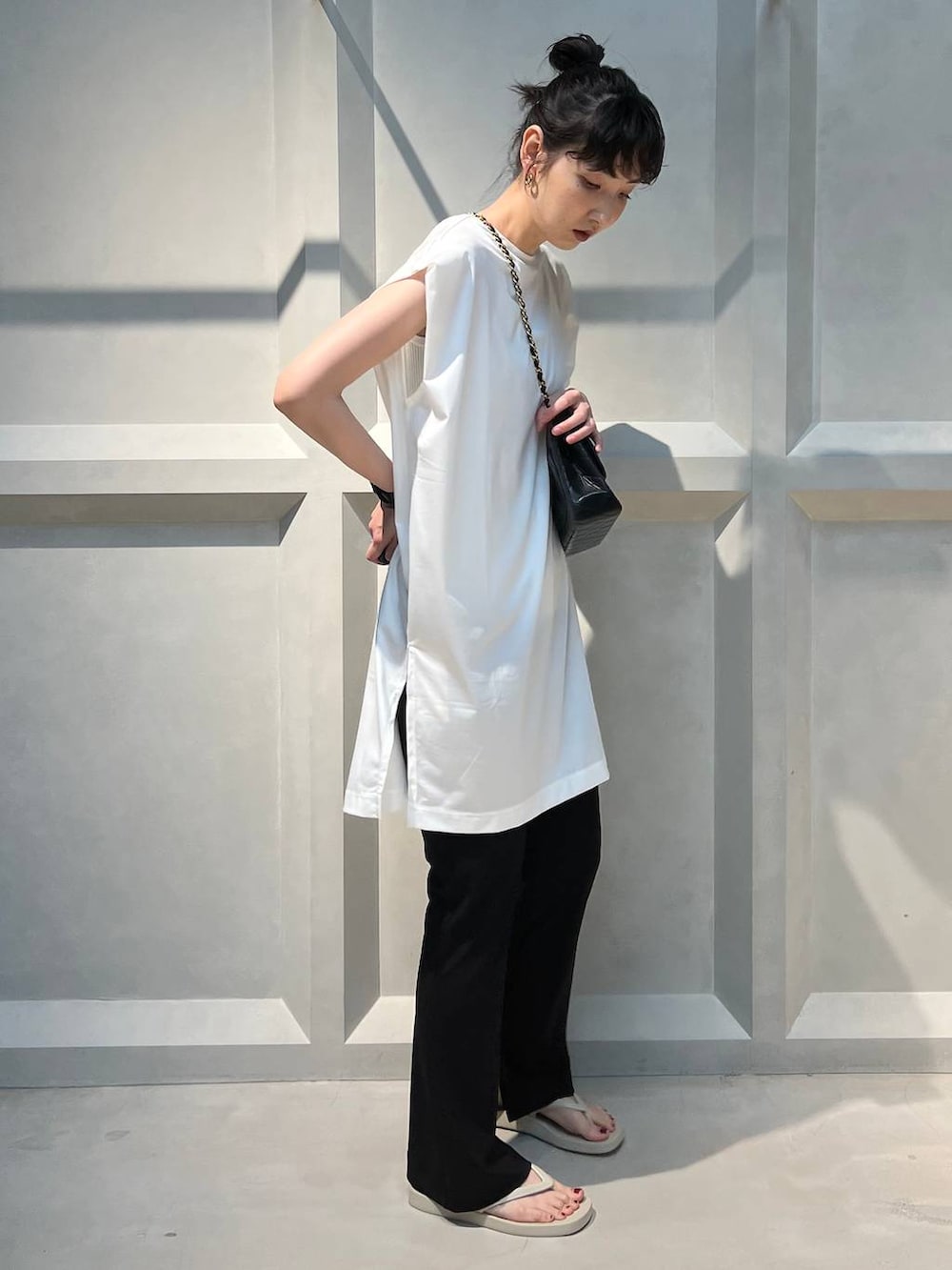 ブラック系のその他パンツ、ホワイト系のTシャツ/カットソー、ベージュ系のサンダルを着用したレディースの夏コーディネートの4枚目の写真