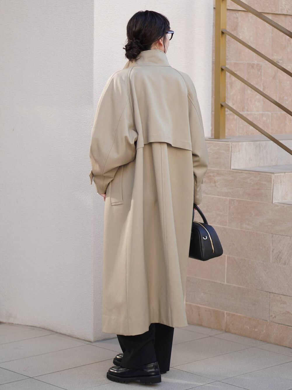 ブラック系のその他パンツ、ベージュ系のトレンチコート、ホワイト系のニット/セーターを着用したレディースの秋コーディネートの2枚目の写真