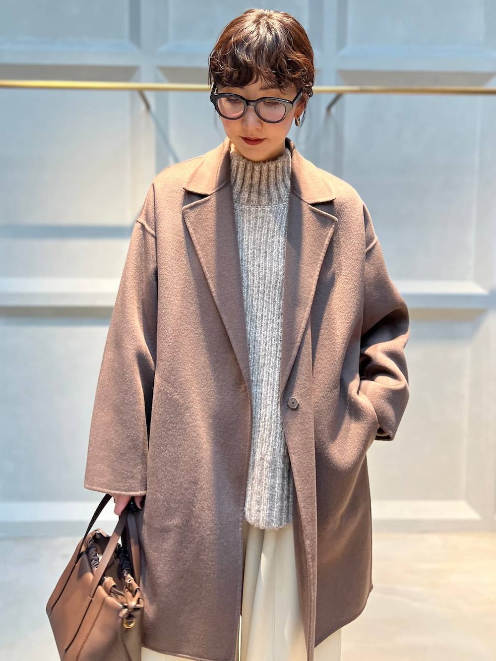 ホワイト系のその他パンツ、ベージュ系のニット/セーター、ブラウン系のチェスターコートを着用したレディースの秋コーディネートの4枚目の写真