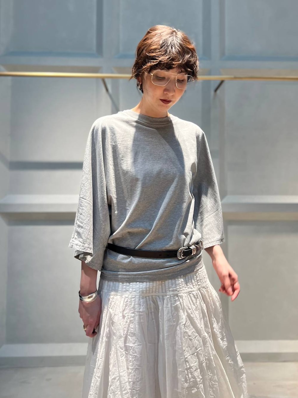 ホワイト系のスカート、グレー系のTシャツ/カットソー、シルバー系のバングル/リストバンドを着用したレディースの夏コーディネートの5枚目の写真