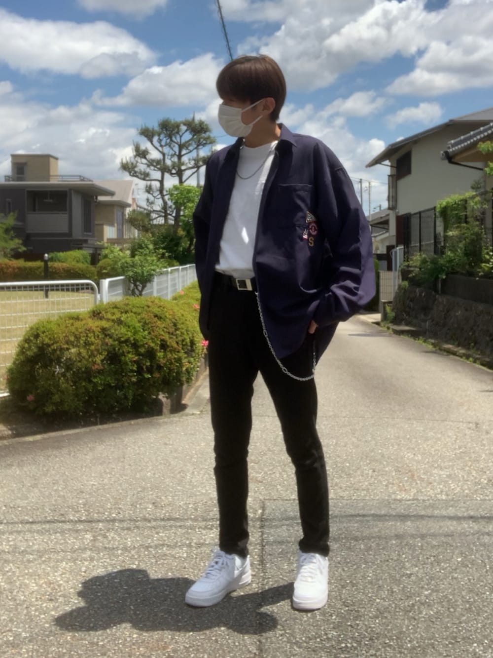 ホワイト系のスニーカー、ホワイト系のTシャツ/カットソー、ブラック系のデニムパンツを着用したメンズの春コーディネートの4枚目の写真