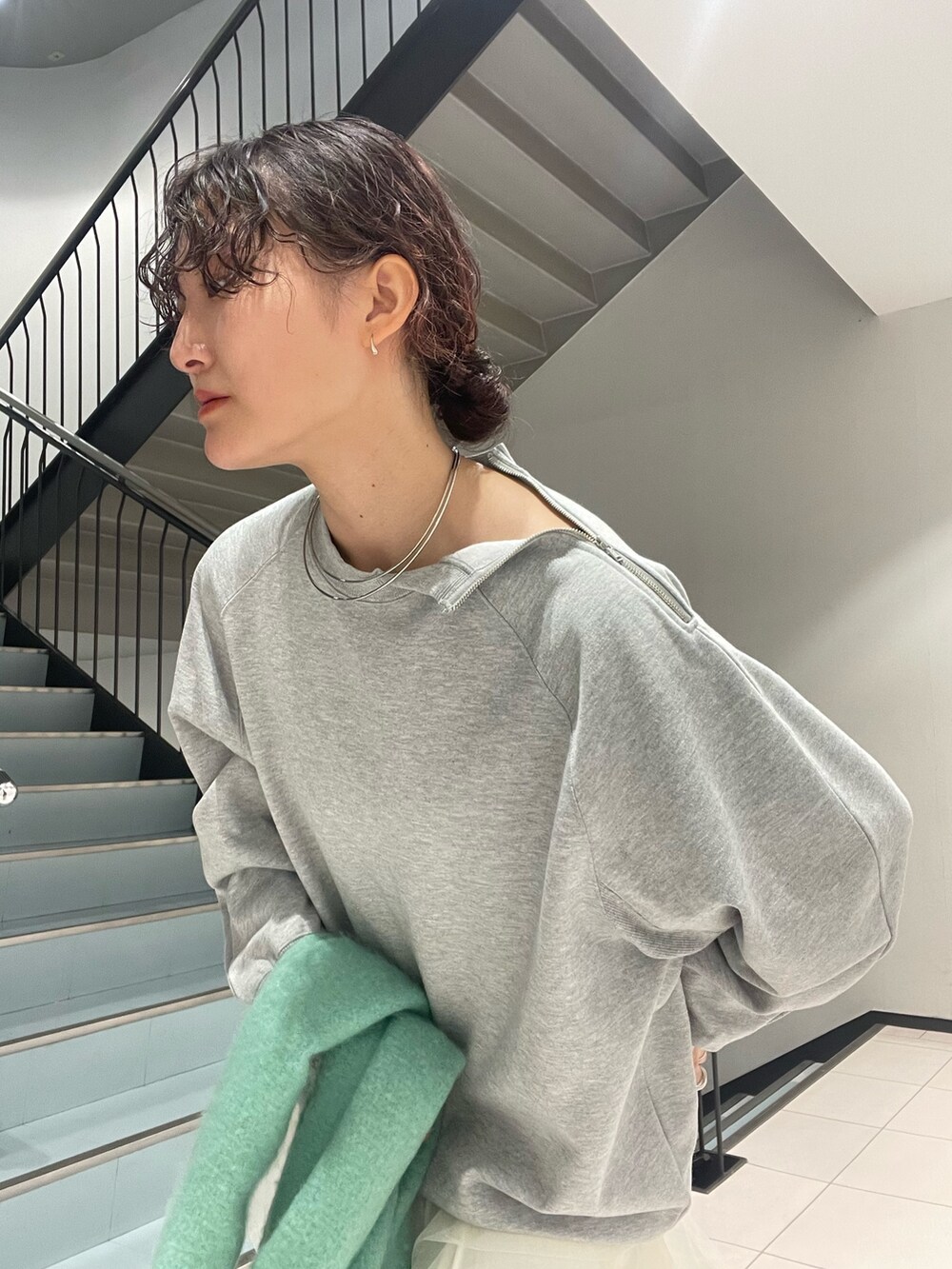 グレー系のスウェット、ホワイト系のスカート、ブラック系のブーツを着用したレディースの秋コーディネートの7枚目の写真