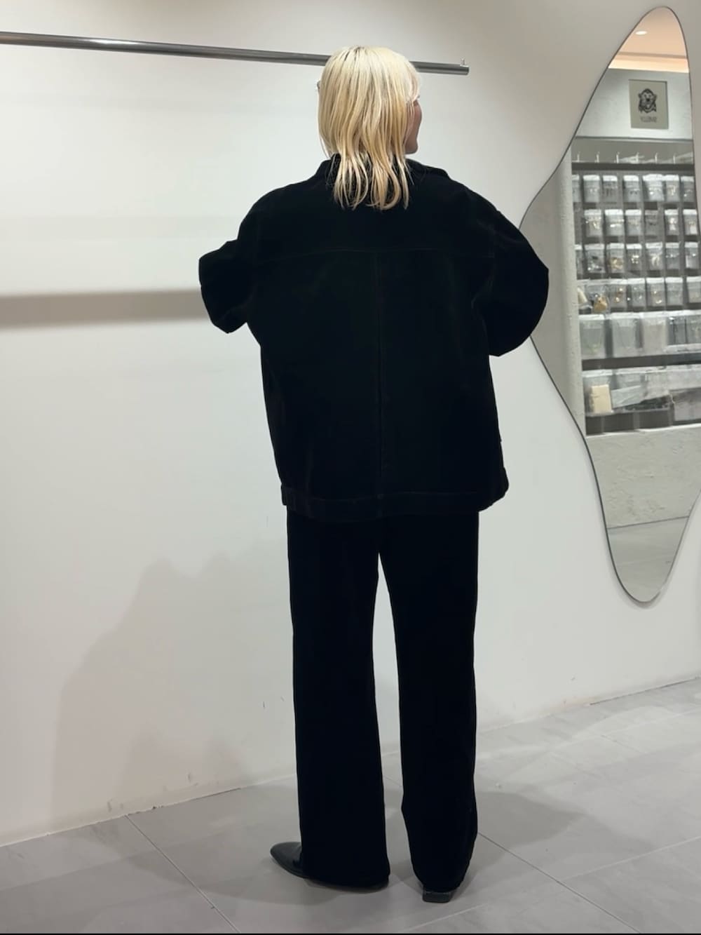 ブラック系のブルゾン、ブラック系のデニムパンツ、ブルー系のニット/セーターを着用したレディースの冬コーディネートの2枚目の写真