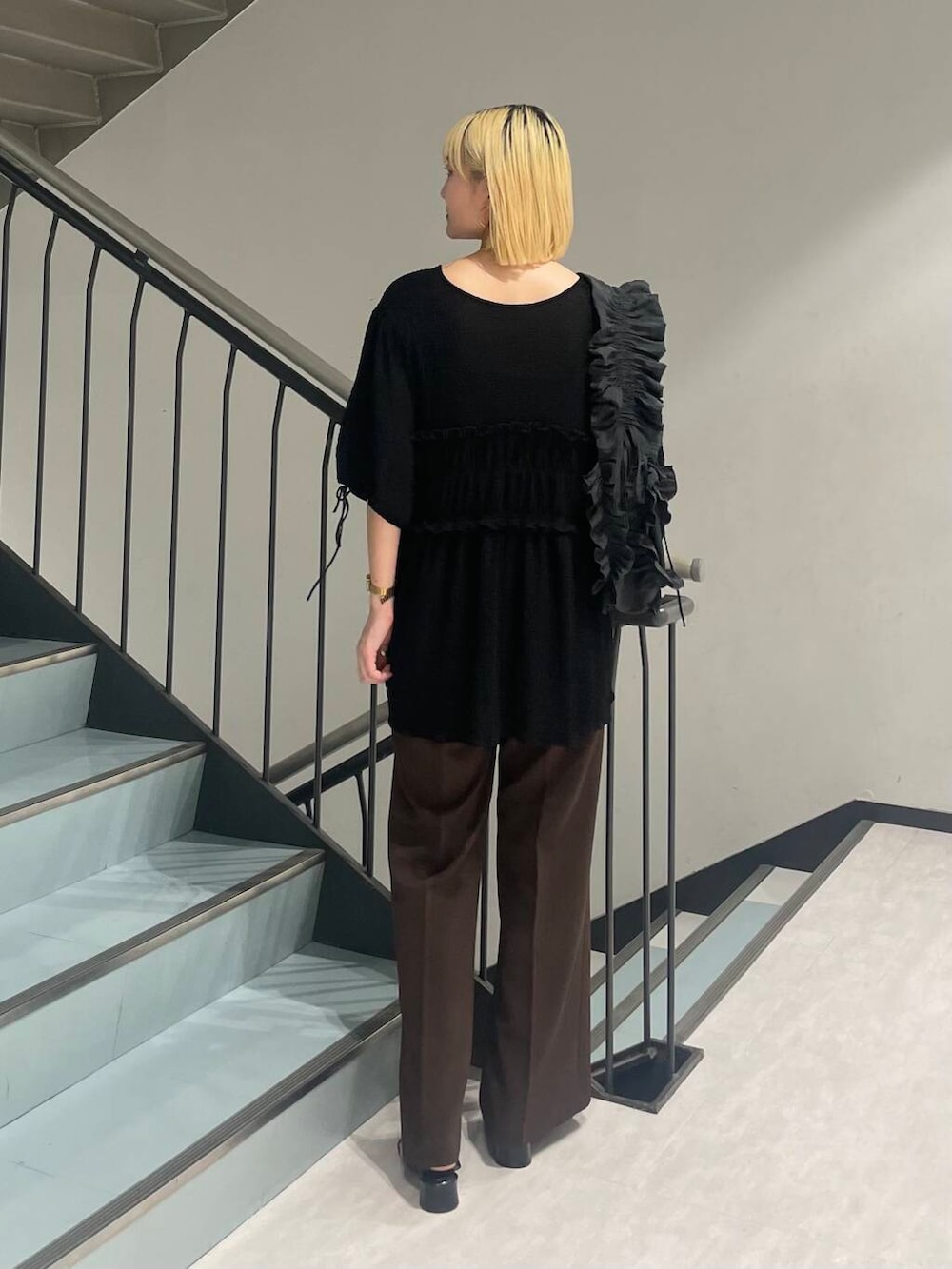 グレー系のショルダーバッグ、ブラック系のパンプス、ブラウン系のその他パンツを着用したレディースの夏コーディネートの3枚目の写真