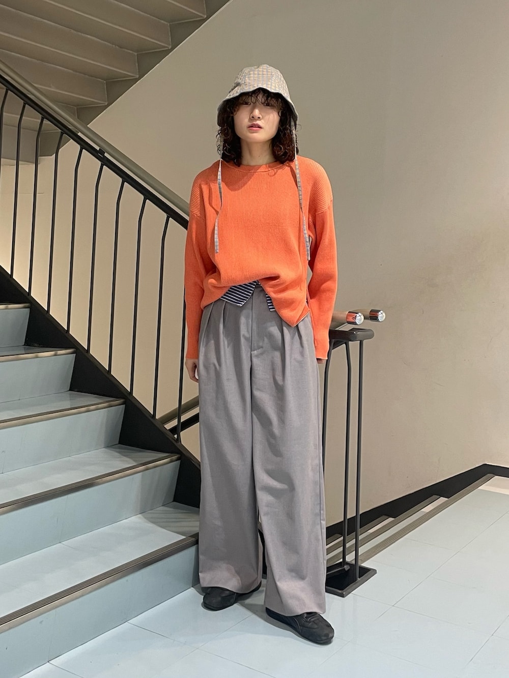 オレンジ系のニット/セーター、グレー系のその他パンツ、オレンジ系のハットを着用したレディースの冬コーディネートの3枚目の写真