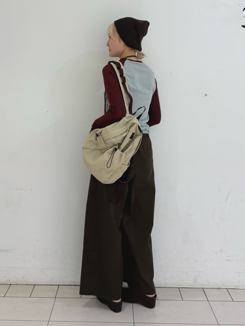 ブルー系のTシャツ/カットソー、ベージュ系のバックパック/リュック、ブラウン系のその他パンツを着用したレディースの春コーディネートの3枚目の写真