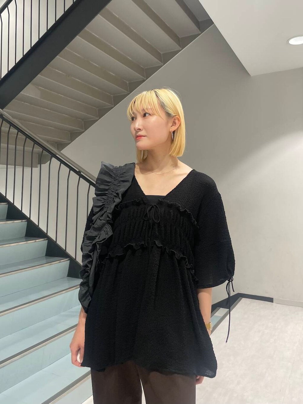 グレー系のショルダーバッグ、ブラック系のパンプス、ブラウン系のその他パンツを着用したレディースの夏コーディネートの5枚目の写真