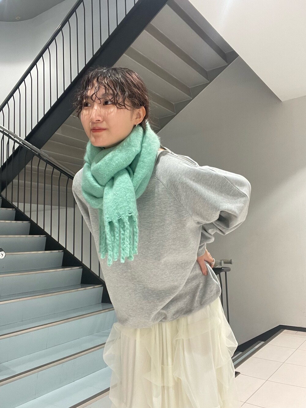 グレー系のスウェット、ホワイト系のスカート、ブラック系のブーツを着用したレディースの秋コーディネートの6枚目の写真