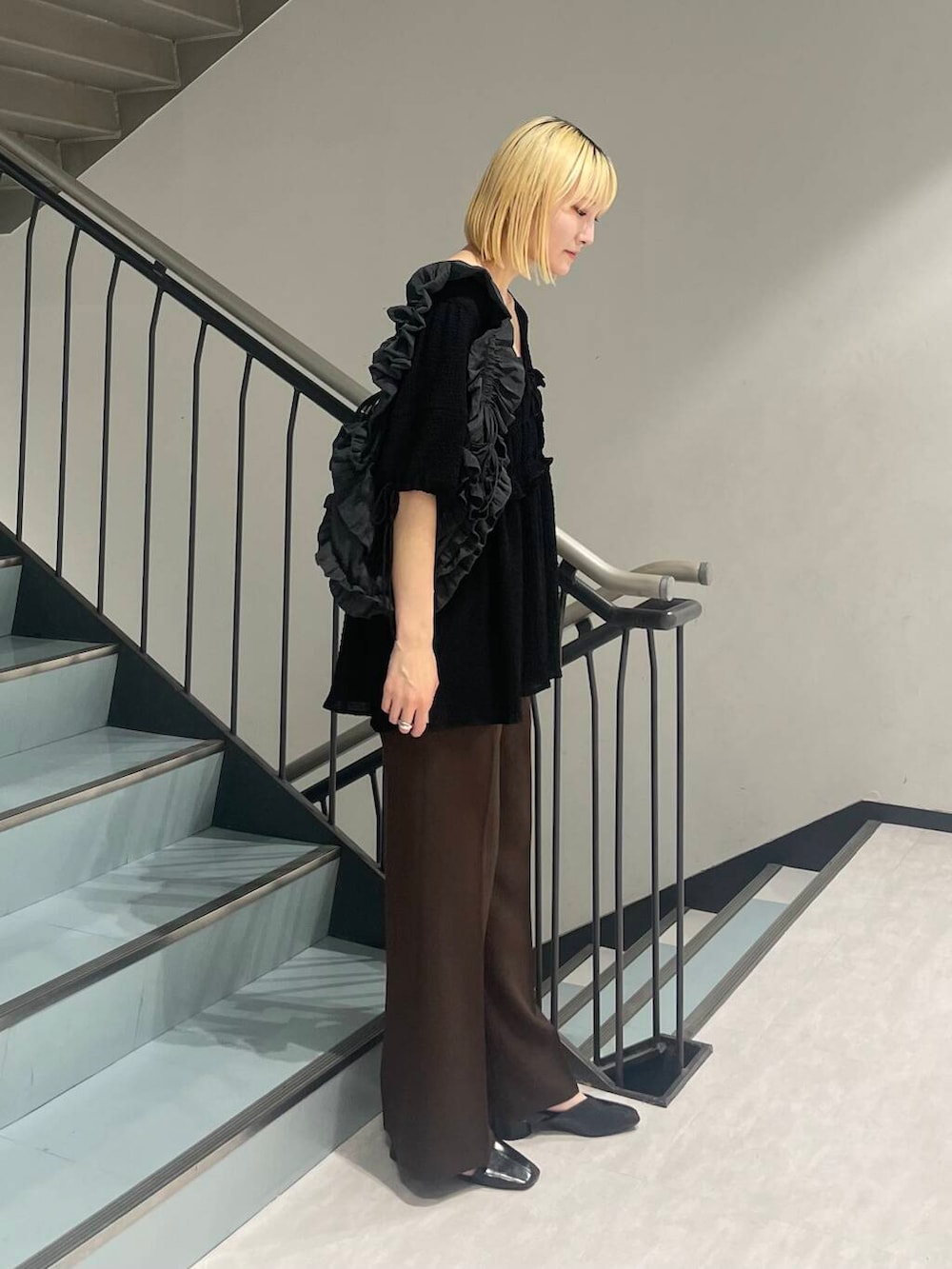 グレー系のショルダーバッグ、ブラック系のパンプス、ブラウン系のその他パンツを着用したレディースの夏コーディネートの4枚目の写真