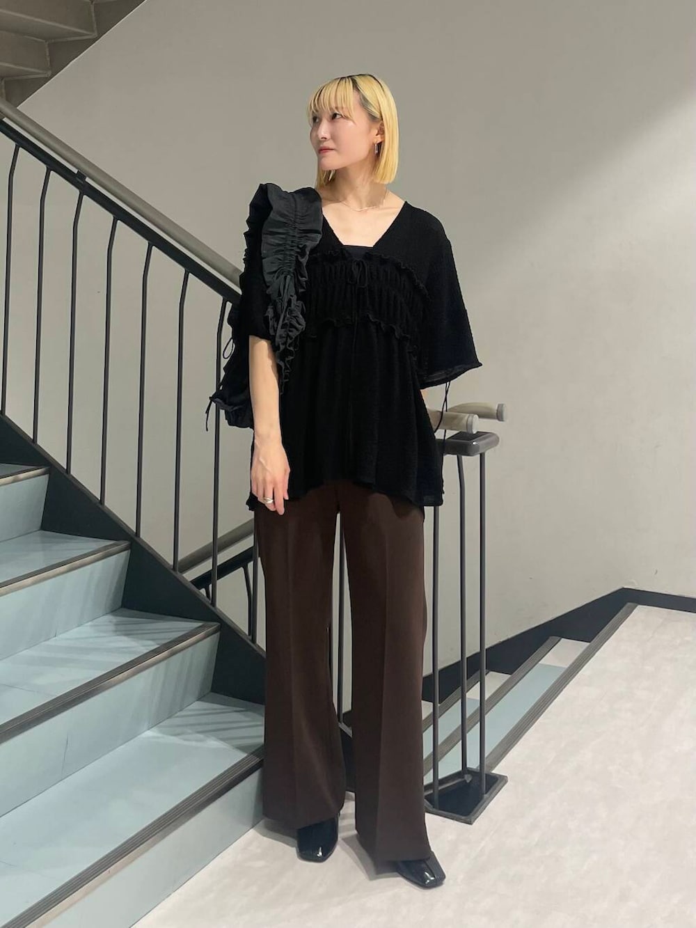 グレー系のショルダーバッグ、ブラック系のパンプス、ブラウン系のその他パンツを着用したレディースの夏コーディネートの2枚目の写真