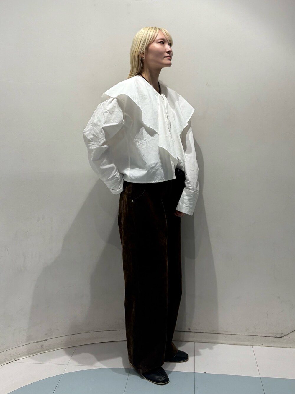 ブラウン系のデニムパンツ、ブラック系のショルダーバッグ、ブラック系のパンプスを着用したレディースの冬コーディネートの2枚目の写真