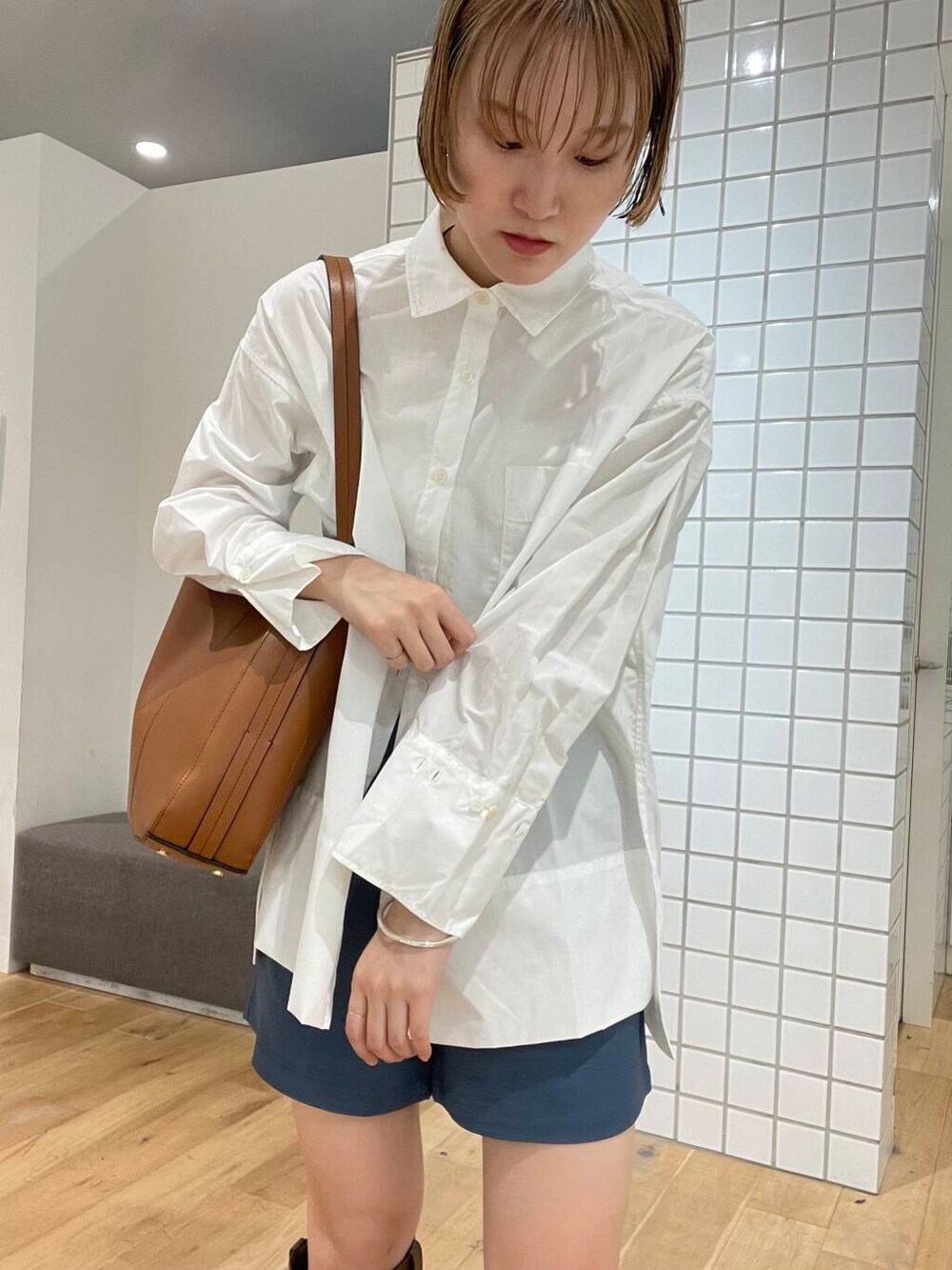 ブルー系のその他パンツ、ブラウン系のトートバッグ、ホワイト系のTシャツ/カットソーを着用したレディースの夏コーディネートの3枚目の写真
