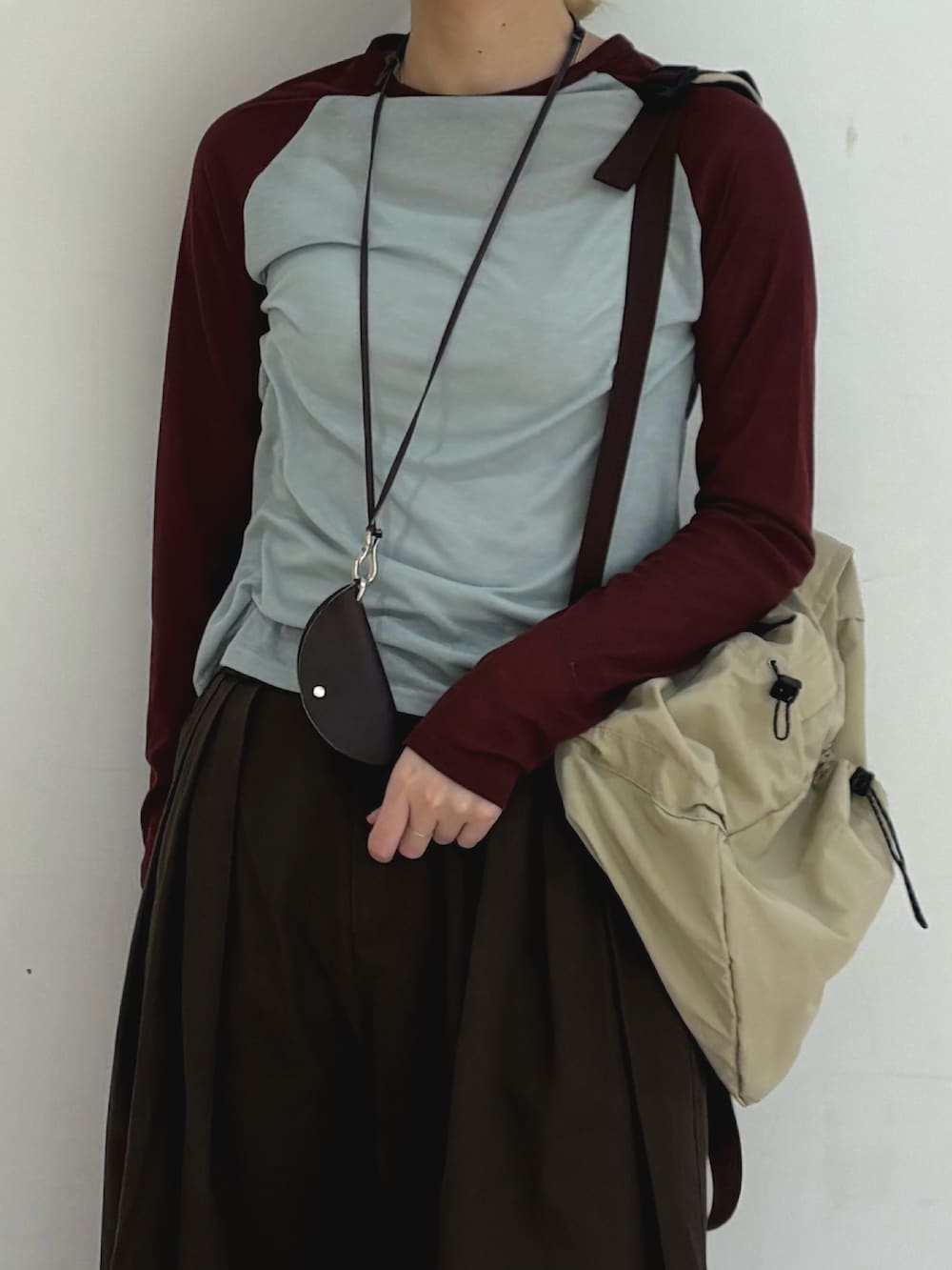 ブルー系のTシャツ/カットソー、ベージュ系のバックパック/リュック、ブラウン系のその他パンツを着用したレディースの春コーディネートの4枚目の写真