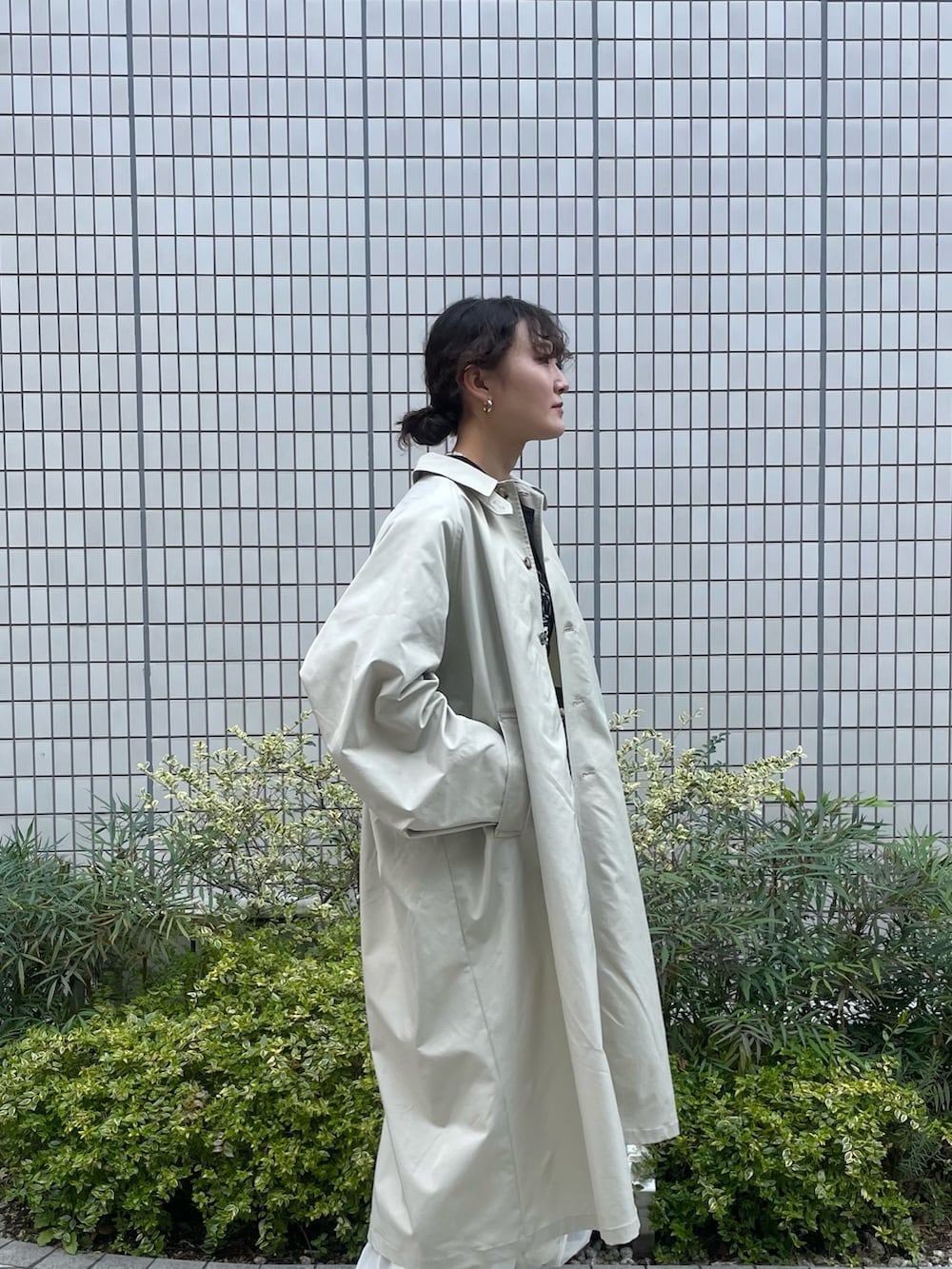 グレー系のステンカラーコート、ホワイト系のその他パンツ、ブラック系のTシャツ/カットソーを着用したレディースの春コーディネートの2枚目の写真