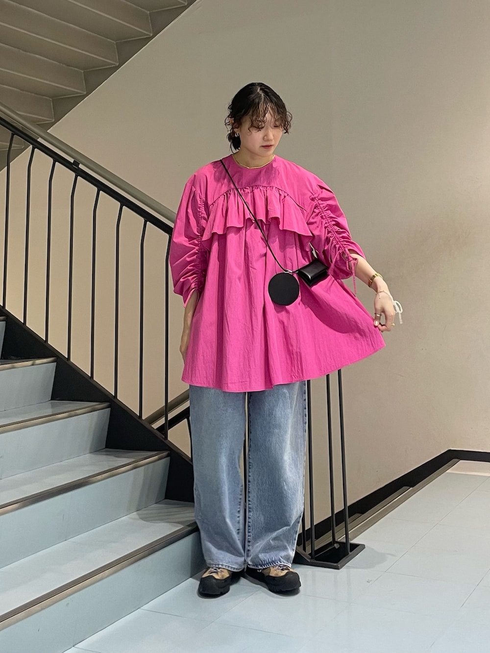 ピンク系のワンピース、ブルー系のデニムパンツ、その他のブレスレットを着用したレディースの春コーディネートの2枚目の写真