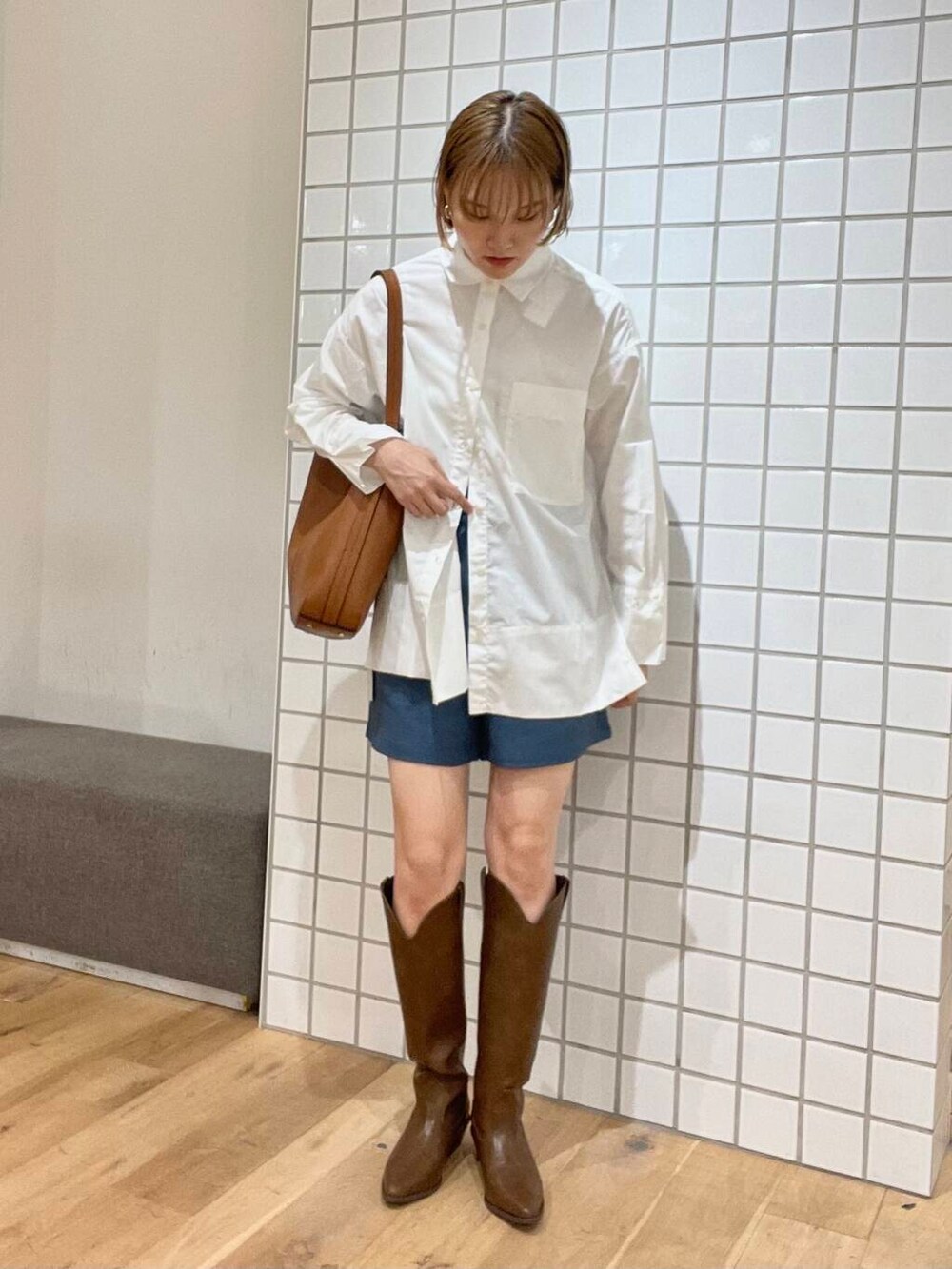 ブルー系のその他パンツ、ブラウン系のトートバッグ、ホワイト系のTシャツ/カットソーを着用したレディースの夏コーディネートの2枚目の写真