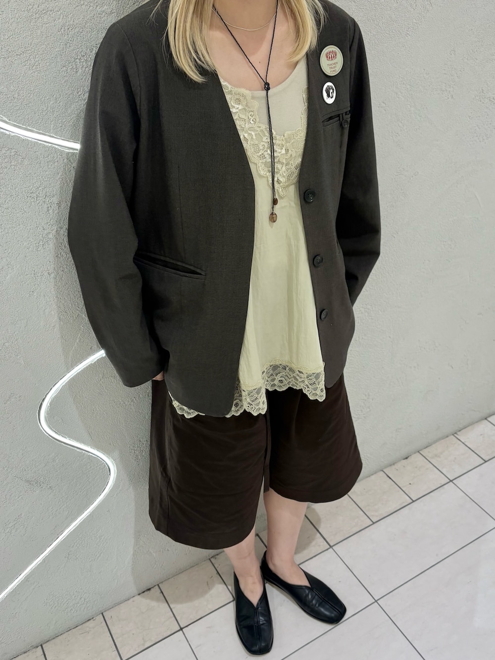 ベージュ系のキャミソール、ブラウン系のノーカラージャケット、ブラウン系のその他パンツを着用したレディースの春コーディネートの4枚目の写真