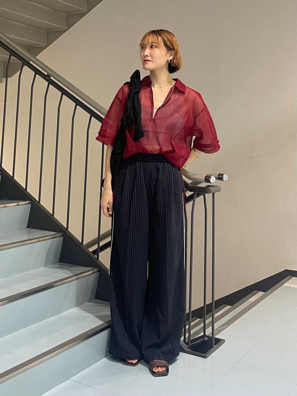 ブルー系のその他パンツ、ブラウン系のサンダル、レッド系のシャツ/ブラウスを着用したレディースの夏コーディネートの2枚目の写真