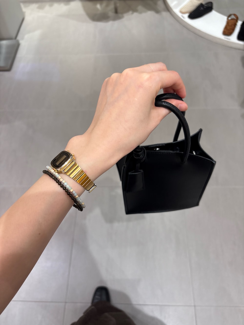 グレー系のカーディガン/ボレロ、ブラウン系のその他パンツ、ブラック系のハンドバッグを着用したレディースの春コーディネートの5枚目の写真