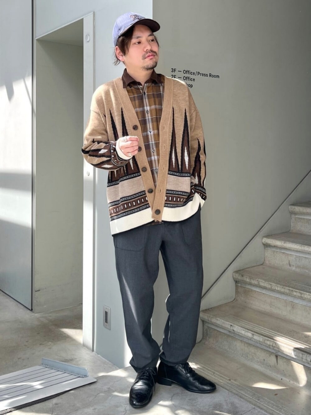 グレー系のスラックス、ブラウン系のカーディガン/ボレロ、ブラウン系のシャツ/ブラウスを着用したメンズの秋コーディネートの2枚目の写真
