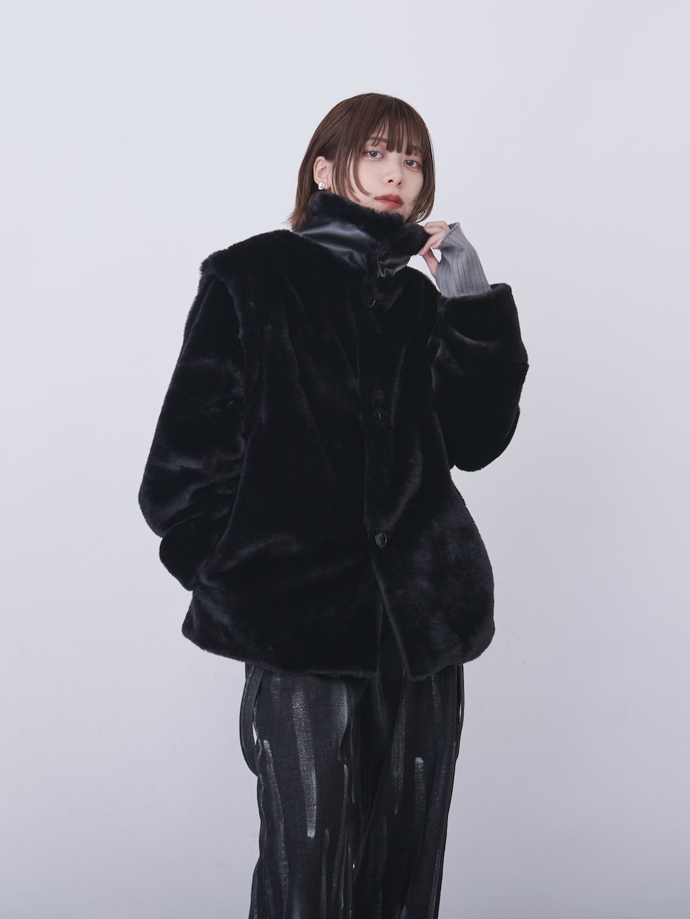 ブラック系のブルゾン、グレー系のニット/セーター、ブラック系のデニムパンツを着用したレディースの冬コーディネートの4枚目の写真