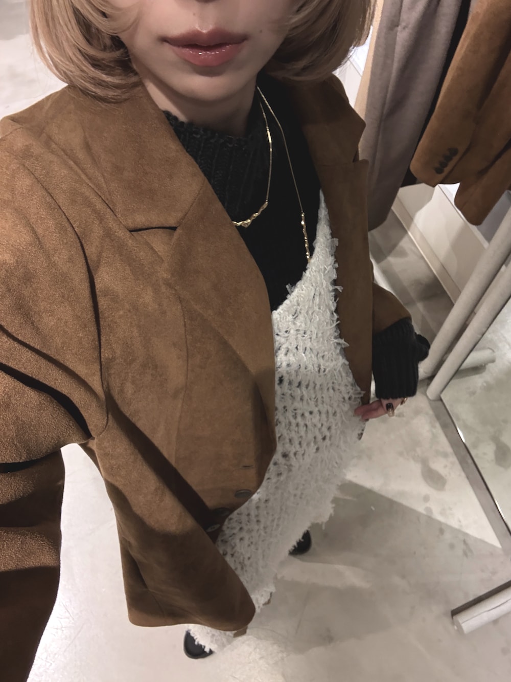 ブラウン系のテーラードジャケット、ブラウン系のデニムパンツ、ベージュ系のワンピース/ドレスを着用したレディースの冬コーディネートの4枚目の写真