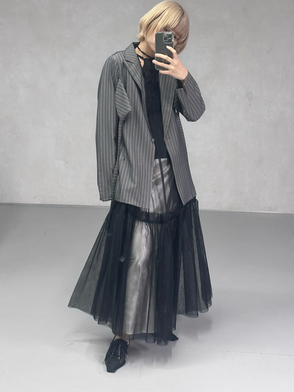 ブラック系のワンピース、ブラック系のパンプス、ブルー系のニット/セーターを着用したレディースの春コーディネートの3枚目の写真