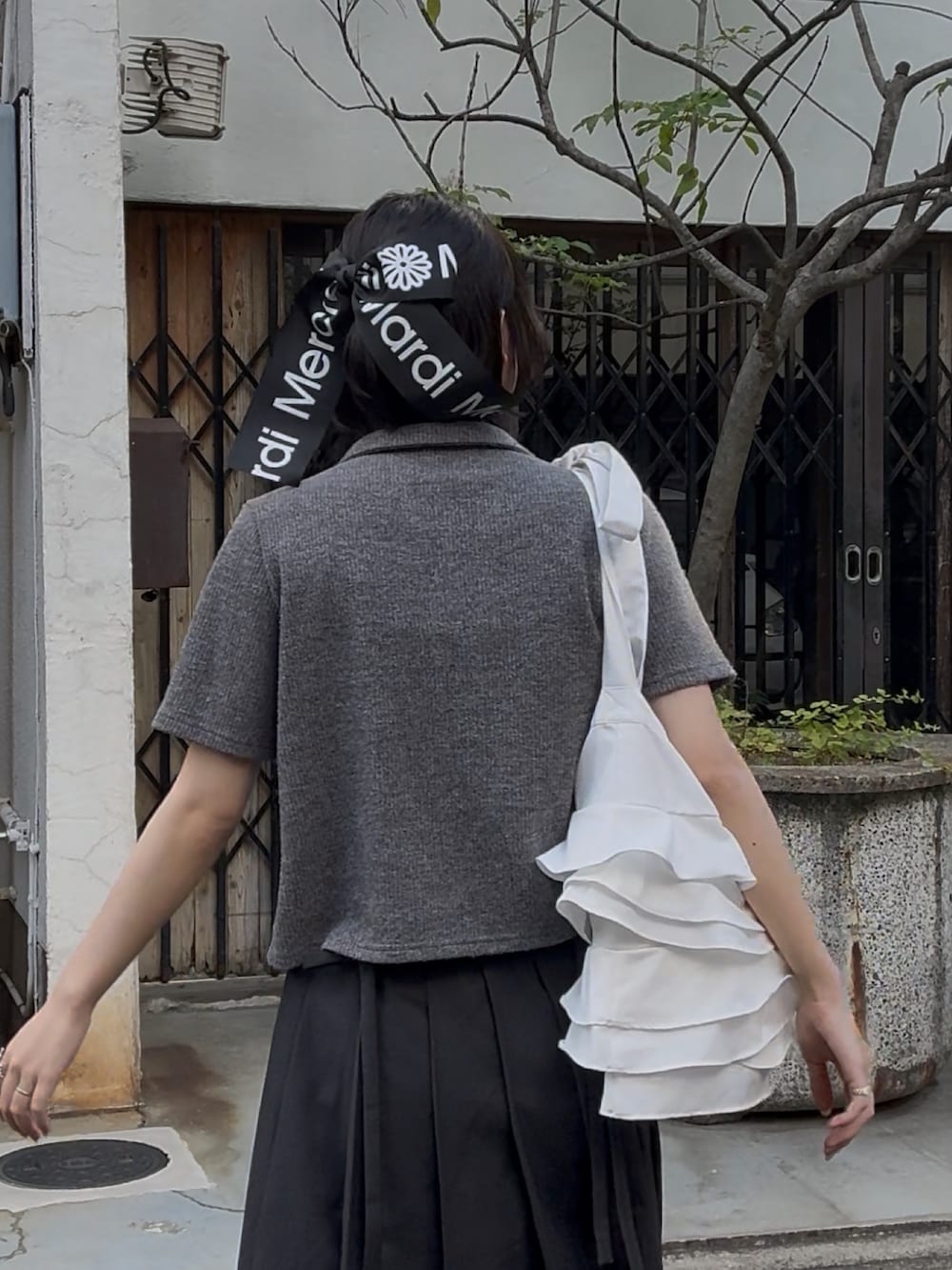 ブラック系のローファー、グレー系のスカート、グレー系のトップスを着用したレディースの秋コーディネートの4枚目の写真