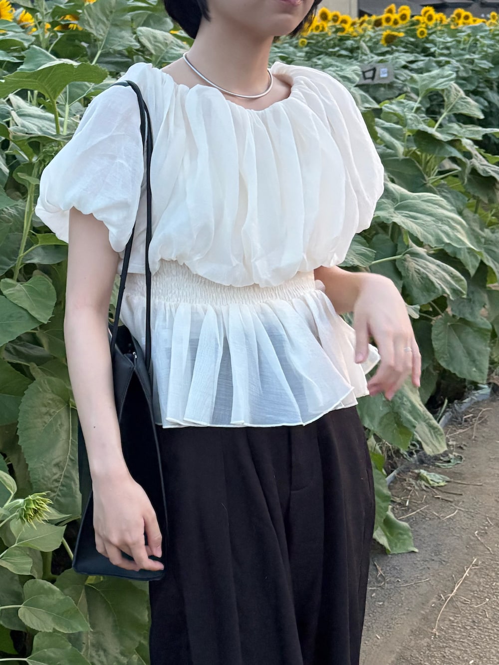 ホワイト系のシャツ/ブラウス、ブラック系のパンツ、ブラック系のショルダーバッグを着用したレディースの夏コーディネートの3枚目の写真