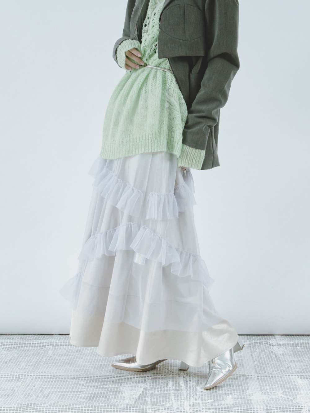 ブルー系のニット/セーター、ブラック系のテーラードジャケット、ホワイト系のワンピースを着用したレディースの冬コーディネートの2枚目の写真