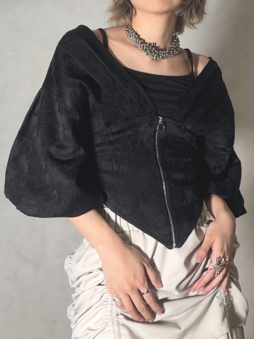 ベージュ系のスラックス、ブラック系のその他トップスを着用したレディースの夏コーディネートの2枚目の写真