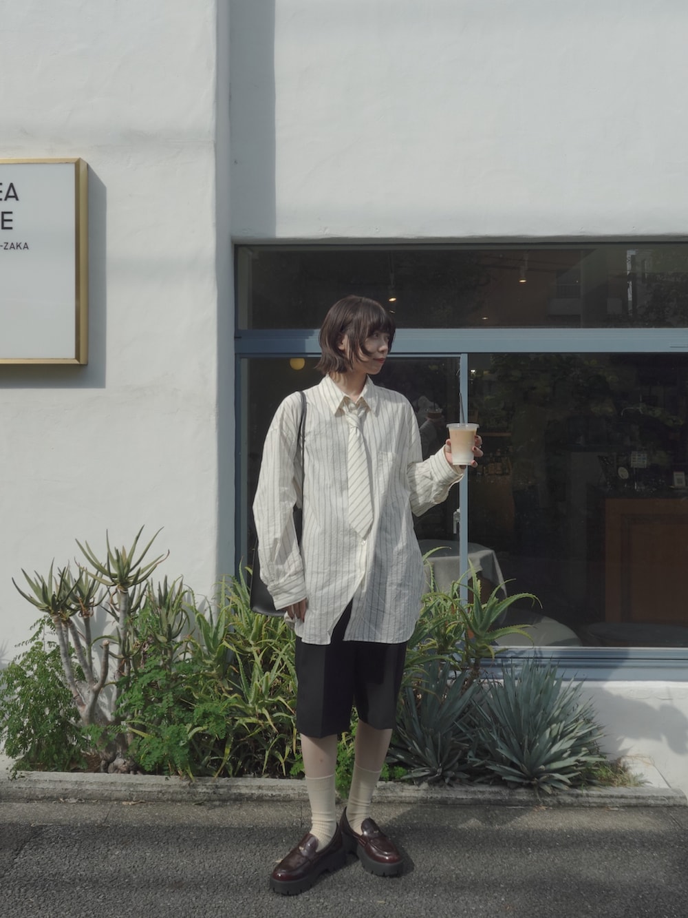 その他のローファー、ブラック系のパンツ、ブラック系のショルダーバッグを着用したレディースの秋コーディネートの2枚目の写真